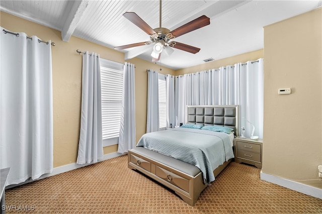 bedroom with beamed ceiling, ceiling fan, and light carpet