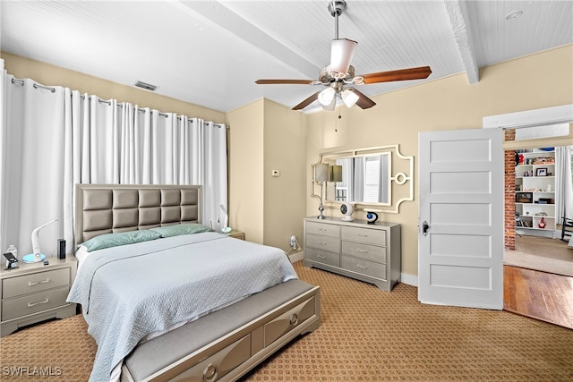 bedroom featuring light carpet, ceiling fan, and beam ceiling