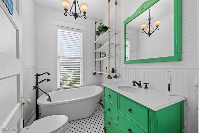 bathroom with a wealth of natural light, a tub to relax in, vanity, and a chandelier