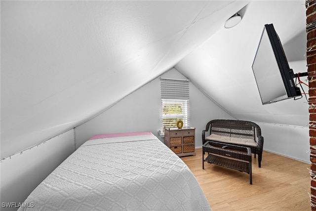 bedroom featuring light hardwood / wood-style floors and vaulted ceiling