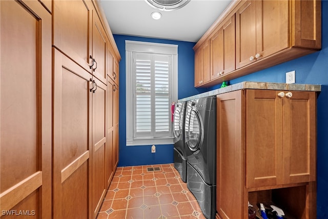 clothes washing area with cabinets and independent washer and dryer