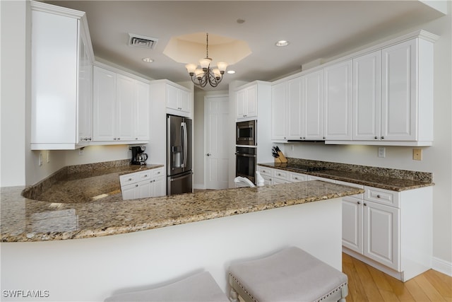 kitchen with stainless steel appliances, light hardwood / wood-style floors, kitchen peninsula, white cabinets, and pendant lighting