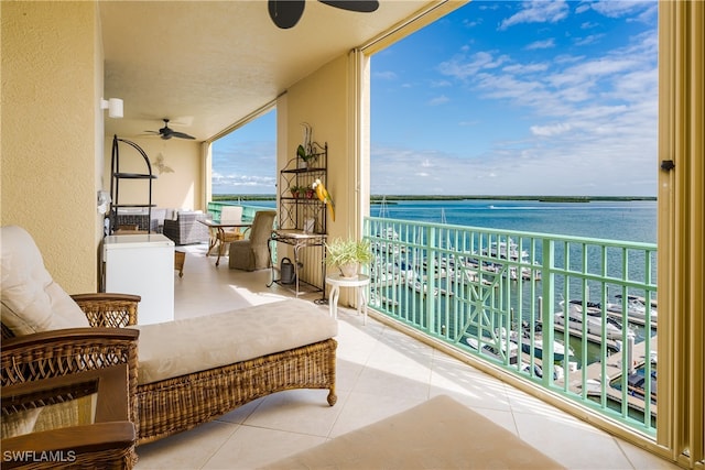 balcony with ceiling fan and a water view