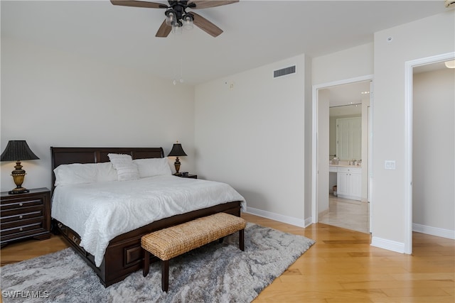 bedroom featuring hardwood / wood-style floors, ensuite bathroom, and ceiling fan