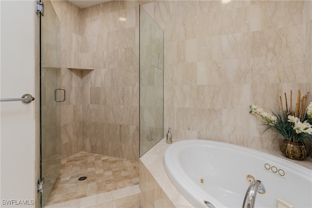 bathroom featuring independent shower and bath and tile walls