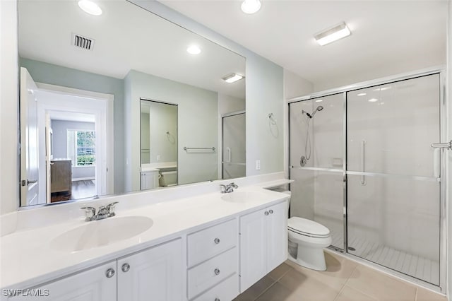 bathroom featuring toilet, vanity, an enclosed shower, and tile patterned flooring