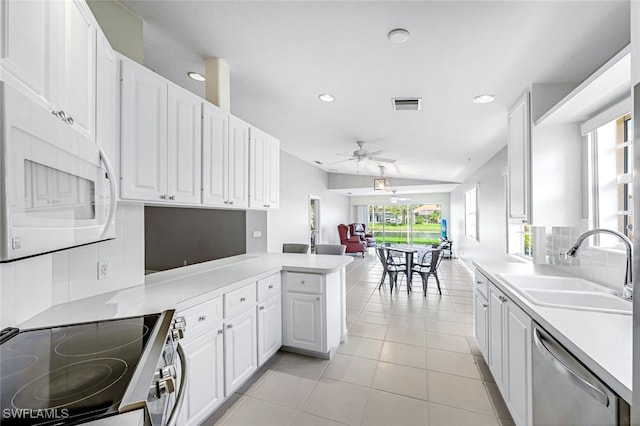 kitchen featuring kitchen peninsula, sink, tasteful backsplash, white cabinetry, and appliances with stainless steel finishes