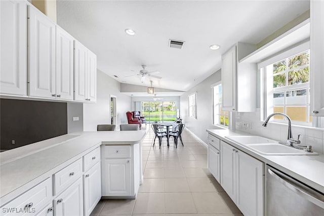 kitchen featuring sink, kitchen peninsula, lofted ceiling, white cabinets, and dishwasher