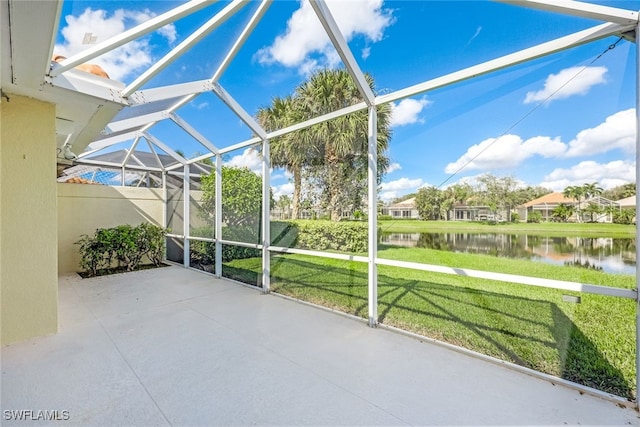 view of patio featuring a water view and a lanai