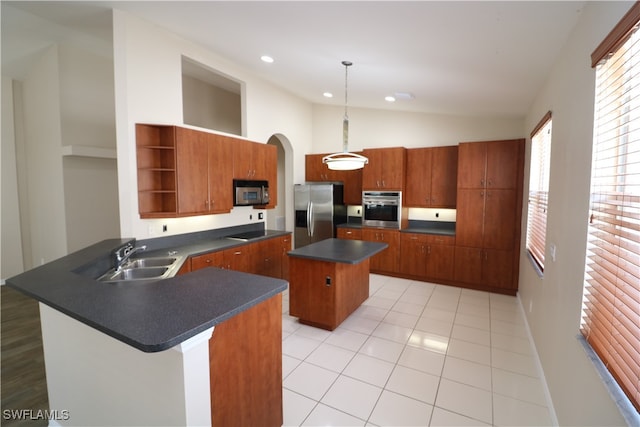 kitchen with kitchen peninsula, appliances with stainless steel finishes, decorative light fixtures, lofted ceiling, and a center island