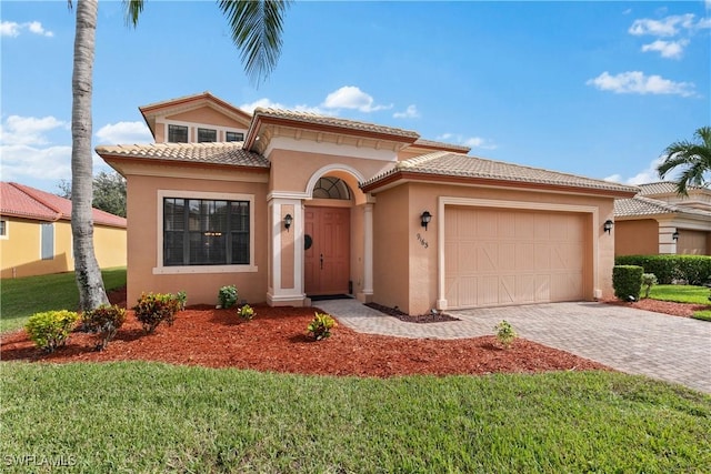 mediterranean / spanish house with a garage and a front lawn