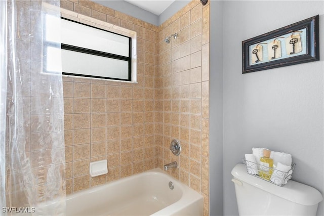 bathroom with toilet and tiled shower / bath