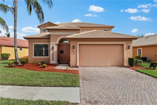 mediterranean / spanish house with a front yard, a garage, and central AC unit