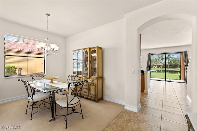 tiled dining room with a chandelier