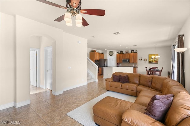 living room featuring light tile patterned floors and ceiling fan