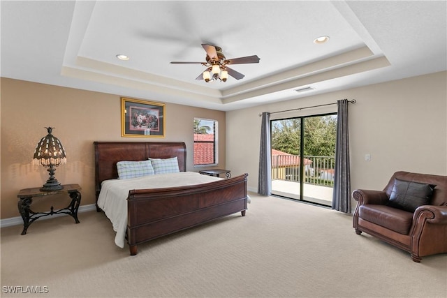 bedroom featuring a tray ceiling, access to exterior, ceiling fan, and light colored carpet