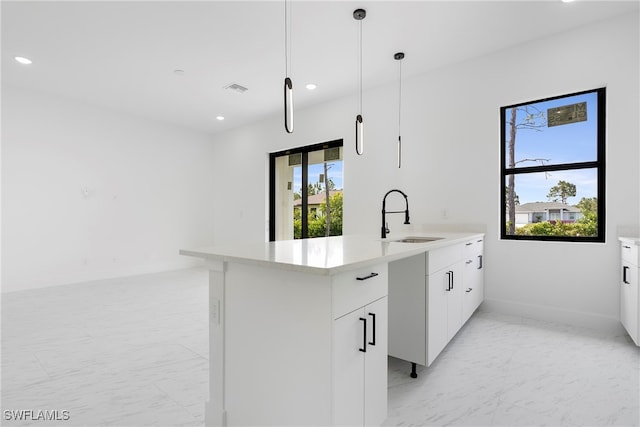 kitchen featuring white cabinetry, sink, and pendant lighting