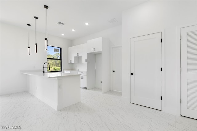 kitchen with white cabinetry, kitchen peninsula, sink, and decorative light fixtures