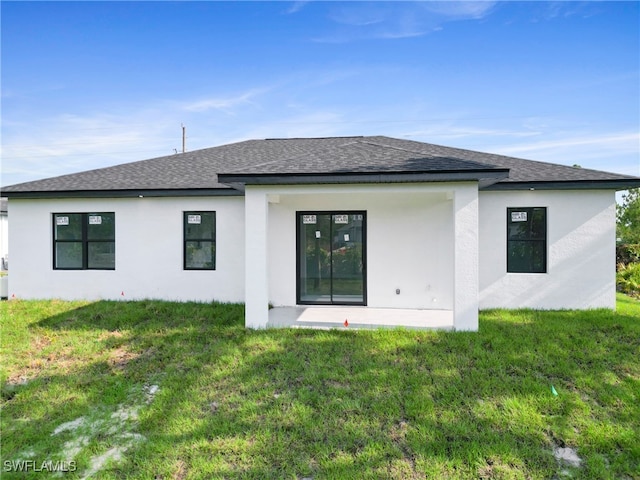 rear view of property featuring a yard