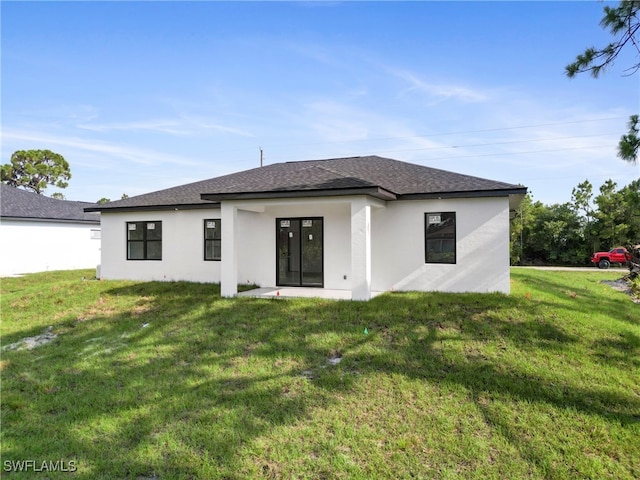 back of house featuring a lawn and french doors