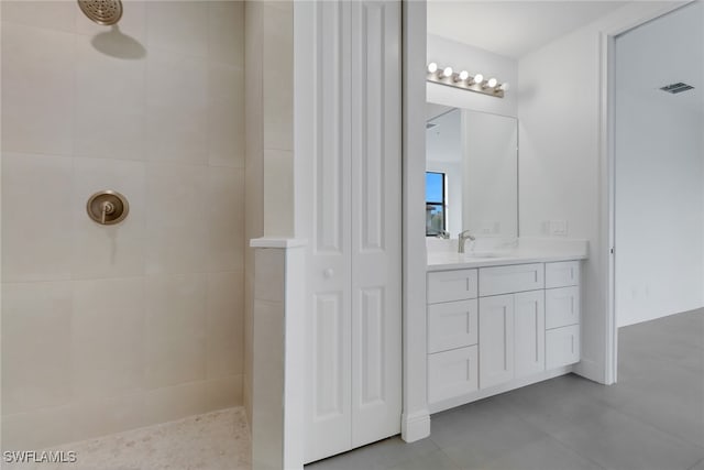 bathroom featuring tiled shower, vanity, and tile patterned floors