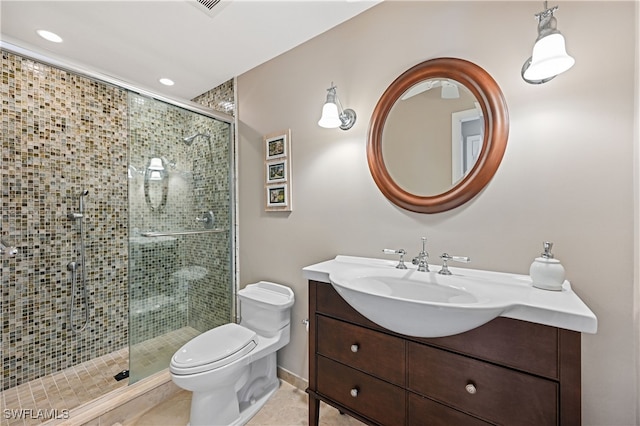 bathroom with tile patterned flooring, vanity, toilet, and a shower with shower door