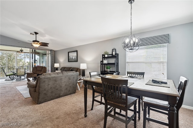 dining space featuring ceiling fan with notable chandelier and carpet