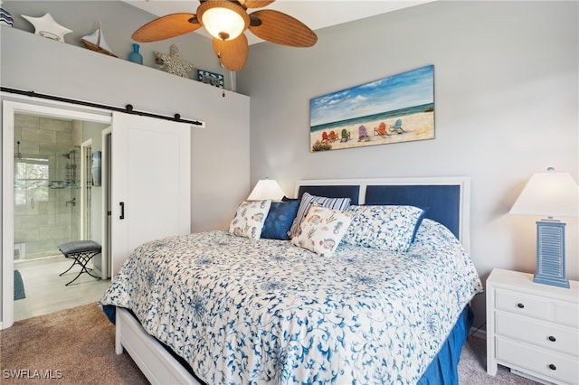 bedroom featuring a barn door, ensuite bathroom, light colored carpet, and ceiling fan