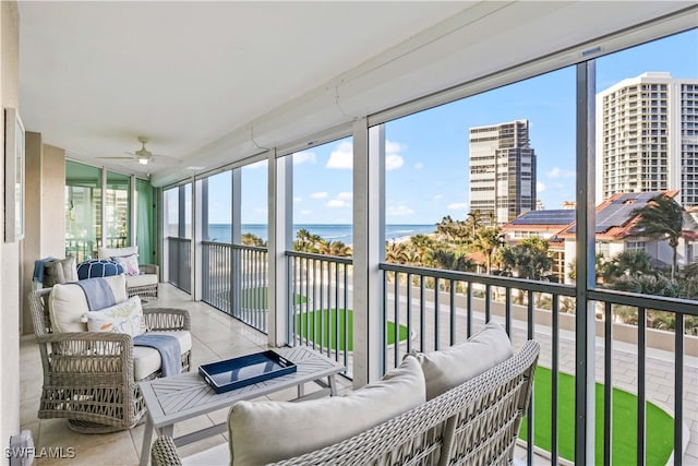 sunroom with a water view and ceiling fan