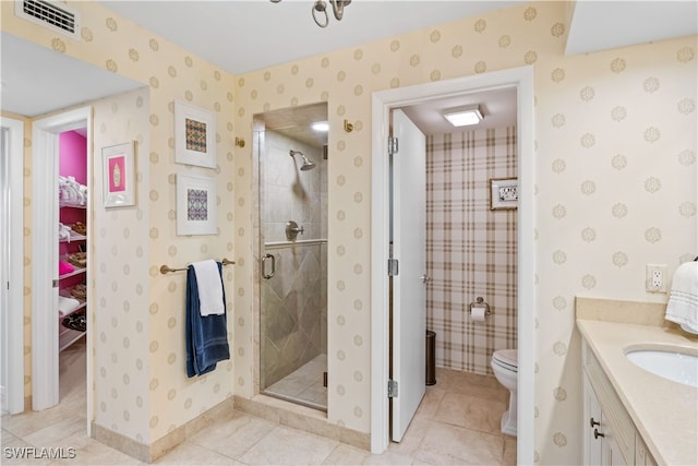 bathroom with vanity, a shower with shower door, tile patterned flooring, and toilet