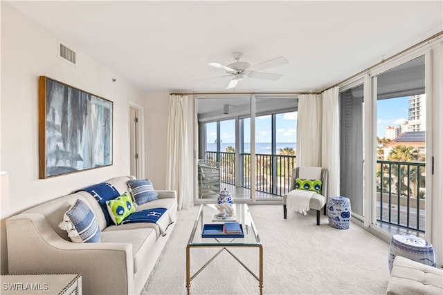 living room featuring expansive windows, carpet floors, and ceiling fan