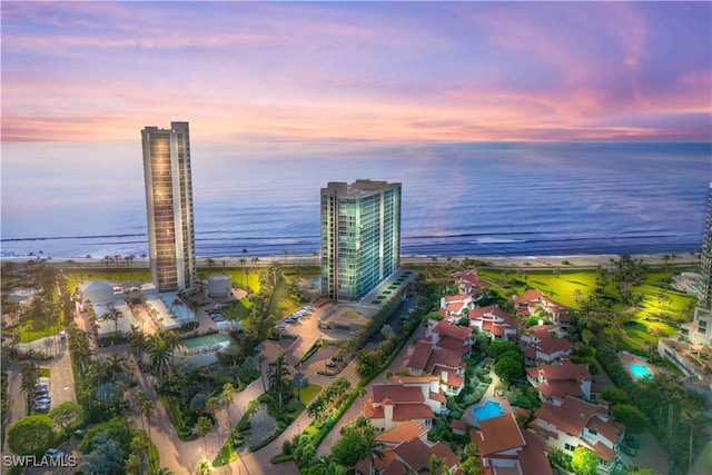 aerial view at dusk featuring a water view