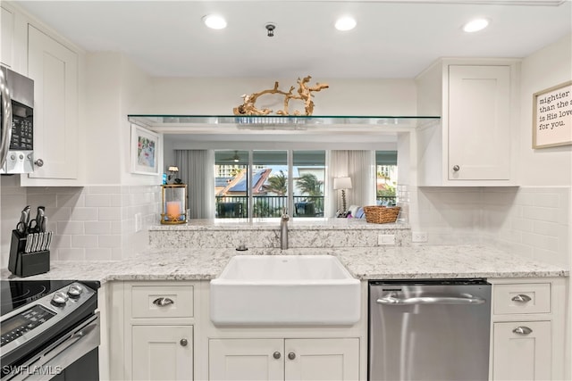 kitchen with white cabinets, appliances with stainless steel finishes, sink, and tasteful backsplash