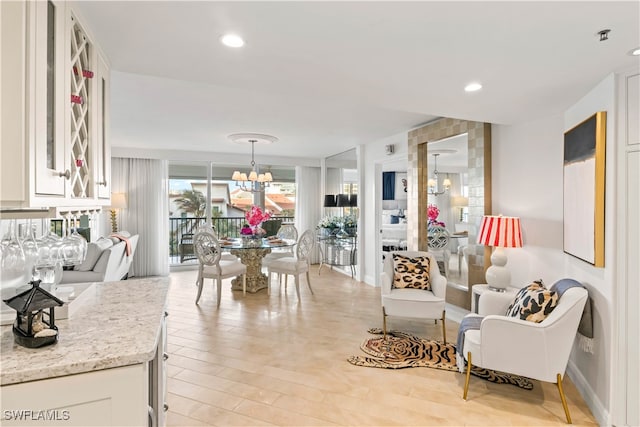 living room featuring light wood-type flooring and a notable chandelier