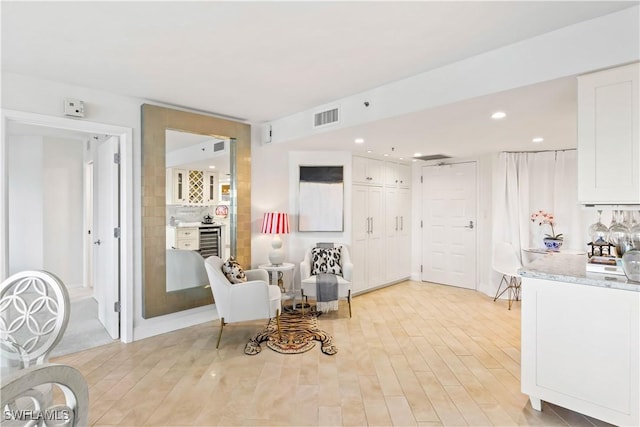 sitting room with recessed lighting, light wood-style floors, visible vents, and wine cooler