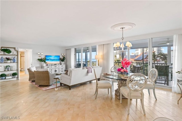 dining area featuring light wood-style flooring and an inviting chandelier