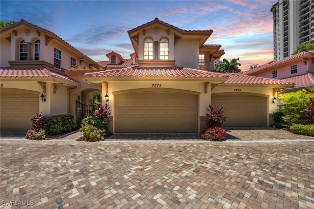 mediterranean / spanish home featuring decorative driveway and stucco siding