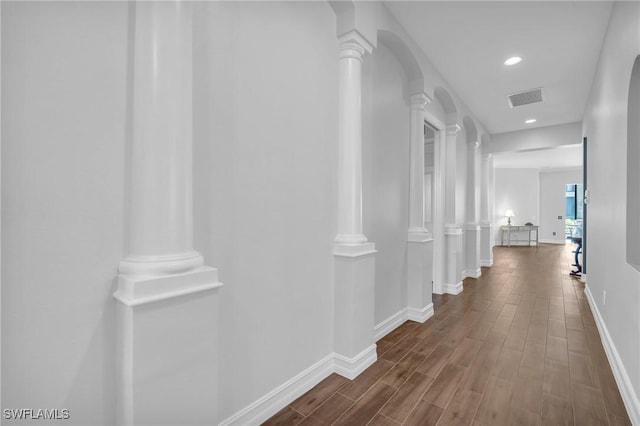 corridor with baseboards, decorative columns, visible vents, and dark wood-style flooring