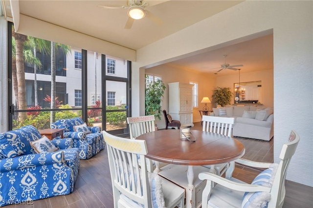 dining space with a sunroom, ceiling fan, and wood finished floors