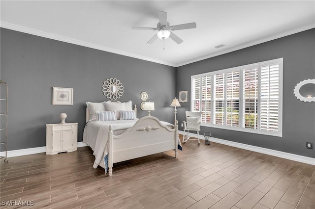 bedroom with wood tiled floor, visible vents, baseboards, and ornamental molding