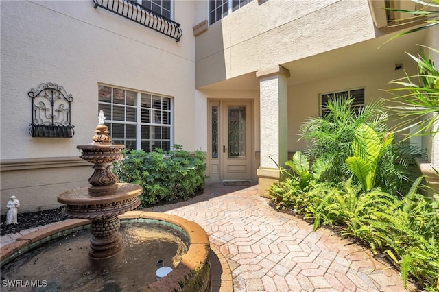 entrance to property featuring stucco siding