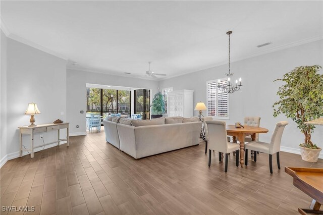 living room with crown molding, baseboards, and wood finished floors