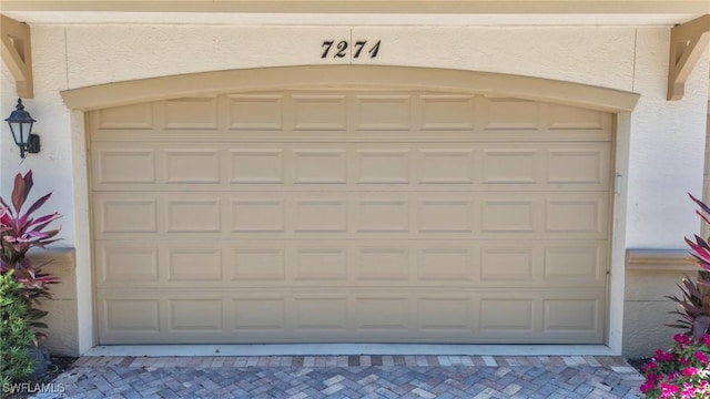 garage with decorative driveway