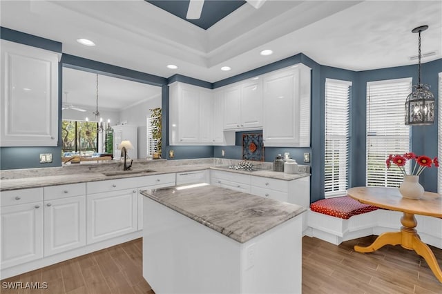 kitchen with hanging light fixtures, breakfast area, a sink, and wood finish floors