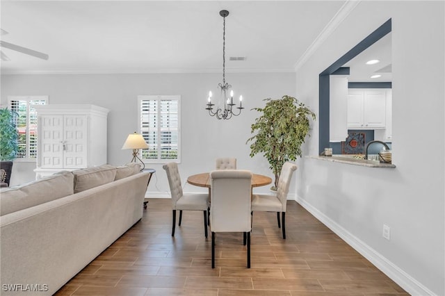 dining space featuring a chandelier, wood finish floors, visible vents, and a healthy amount of sunlight