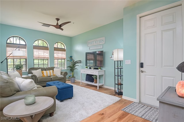 living room featuring ceiling fan, plenty of natural light, and hardwood / wood-style flooring