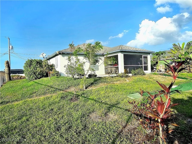 rear view of house with a sunroom and a yard