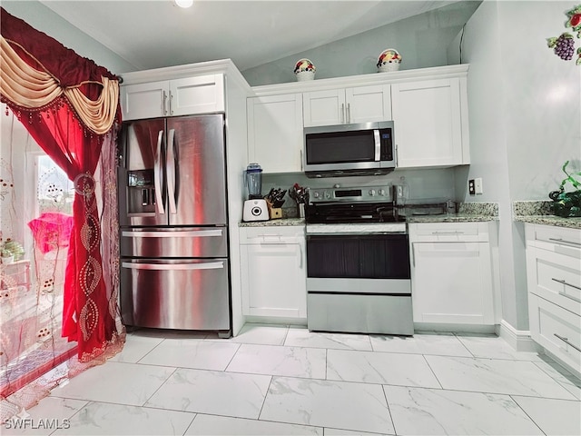 kitchen with white cabinetry, appliances with stainless steel finishes, lofted ceiling, and light stone countertops