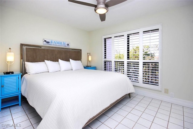 bedroom with light tile patterned floors, a ceiling fan, and baseboards