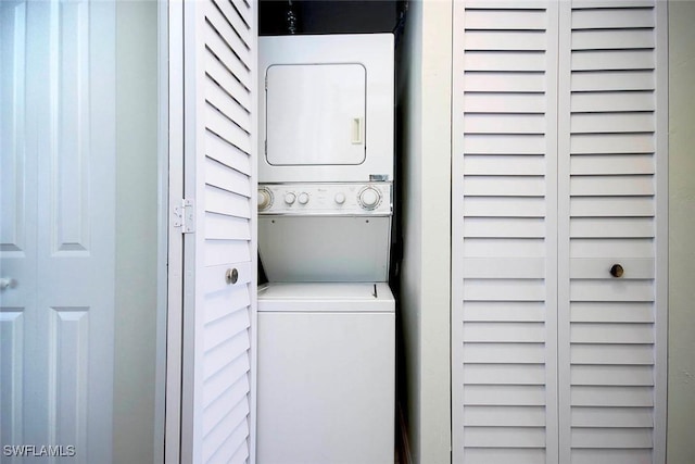 clothes washing area with stacked washer and dryer and laundry area